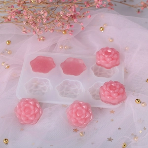 Dettaglio di uno stampo in silicone a 6 rose con fiori in resina rosa su fondo in rete