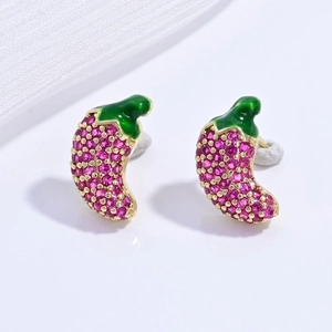 Macro view of chili pepper earrings with pink crystals and green enamel details