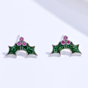 Close-up of glittery green holly leaf earrings with pink cubic zirconia berries