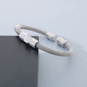 Detail of silver twisted cable cuff bracelet with hexagonal center charms on a dark pedestal