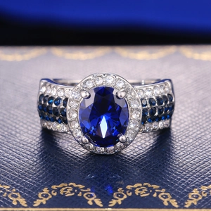 Macro view of luxurious oval blue sapphire ring with sparkling diamond halo on band