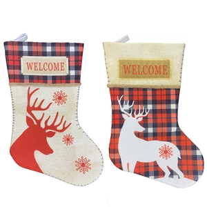Set of two Christmas stockings with reindeer silhouette and festive plaid patterns