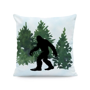 Detailed view of square linen pillow featuring a black Bigfoot silhouette in pine forest