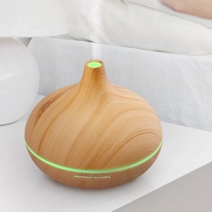 Ultrasonic wood grain essential oil diffuser with green LED light on white nightstand