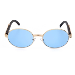 Detalle de gafas de sol redondas con lentes azul claro y montura de metal dorado con textura