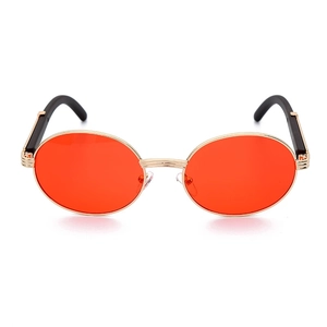 Detalle de gafas de sol redondas con lentes naranjas y montura dorada con patillas negras