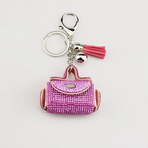 Pink rhinestone handbag keychain with fringe tassel and silver lobster clasp on white background