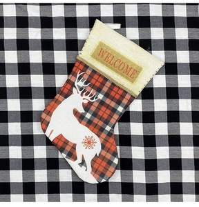 Détail de chaussette de Noël en lin avec motif de renne et broderie texte WELCOME