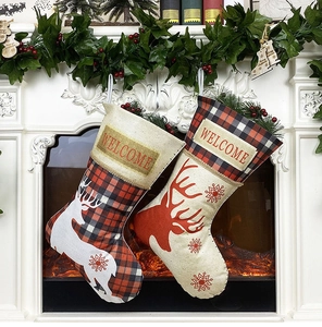 Détail de chaussettes de Noël avec motifs de renne sur un fond de cheminée blanche