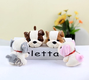 Adorable plush French Bulldog keychains in four colors arranged on a white gift box