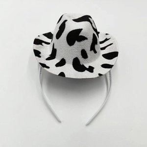 Close-up of black and white cow print mini cowboy hat headband for party accessories