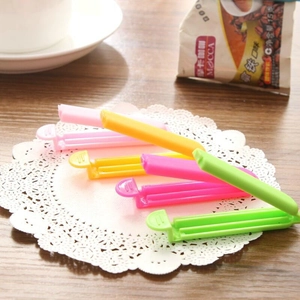 Set of 4 colorful 7cm frosted plastic food sealing clips on a wooden tabletop