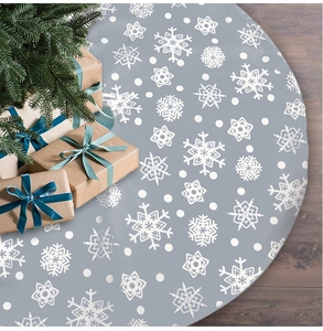 Close-up of gray Christmas tree skirt with white snowflakes on dark wood floor