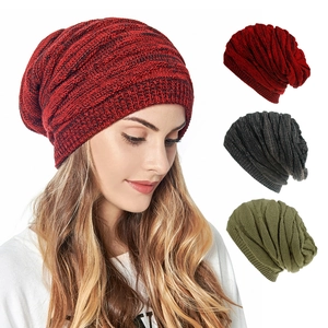 Detail view of knitted beanie hats in red, dark gray and army green colors