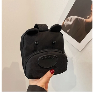 Close-up of black cartoon bear mini handbag with 3D ears and front zipper pocket