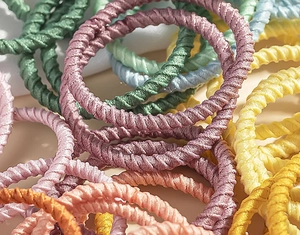 Macro shot of colorful woven elastic hair bands showing texture and vibrant colors