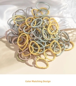 Macro view of multi-colored spiral hair ties in soft Morandi colors on silk fabric