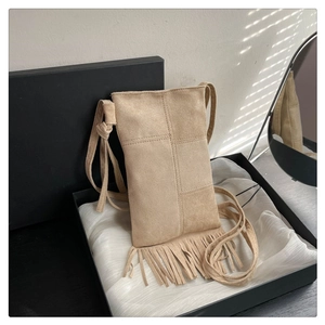 Detail of bohemian light khaki suede phone bag with fringe tassels in a gift box