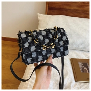 Détail du sac à bandoulière en tweed à carreaux avec franges et chaîne décorative