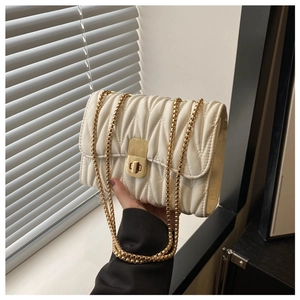 Detail of off-white matelasse quilted leather bag with gold chain and twist lock