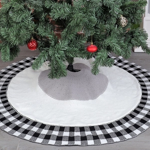 Detail of knitted Christmas tree skirt featuring grey, white, and black plaid pattern