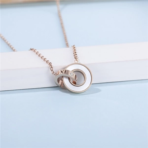 Détail du collier double anneau en or rose avec chiffres romains et nacre blanche