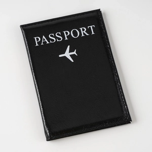Classic black faux leather passport cover with white plane icon and text on white background