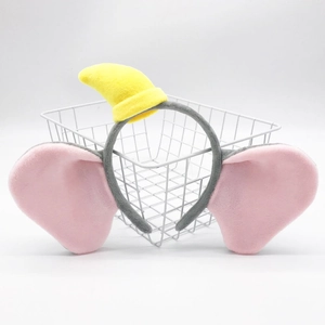 Close-up of plush Dumbo elephant headband with pink ears and yellow hat in a wire basket