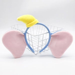 Detail of plush cartoon headband with large pink ears and yellow hat in a basket