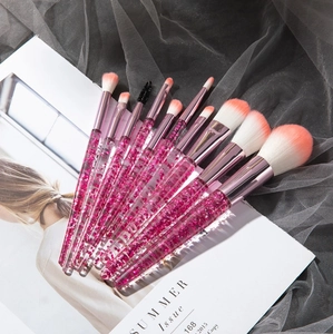 Detail of pink glitter liquid sand handles and soft pink-white gradient makeup brush bristles