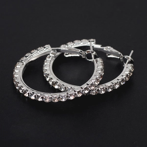Sparkling silver hoop earrings for women featuring dense rhinestone inlay on dark background