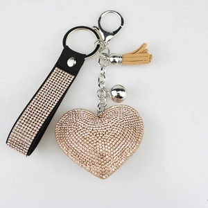 Sparkling diamond heart keychain with rose gold fringe and leather strap on white background