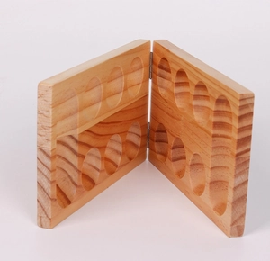 Detail view of the wooden Mancala board game with 16 circular slots and sturdy hinges