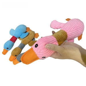 Close-up of pink corduroy duck plush pet toy held in hand showing long soft texture