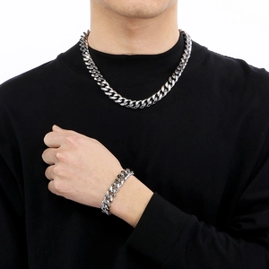 Men's silver stainless steel Cuban link necklace and bracelet set on male model