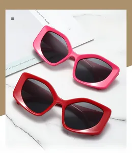 Detail view of bold thick-frame sunglasses in vibrant rose pink and classic red colors