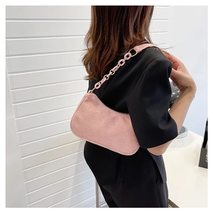 Detailed shot of pink corduroy shoulder bag with plastic chain strap on model