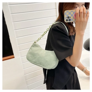 Mirror selfie showing a light green corduroy shoulder bag with matching chain strap