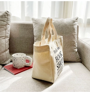 Detail of beige canvas tote bag featuring Brick Lane Book Shop black printed typography