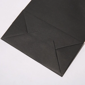 Close-up of the reinforced bottom fold and craft construction of the black paper gift bag