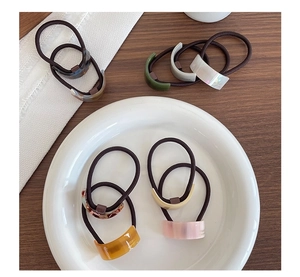 Detail of colorful acetate hair ties with geometric marble patterns and gold label detail