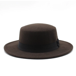 Detail of high-density brown wool felt boater hat with a decorative black satin ribbon