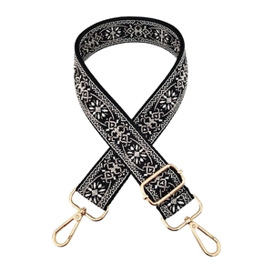 Detail of colorful jacquard wide bag strap with gold metal hooks and geometric embroidery