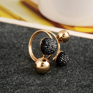 Macro shot of gold-plated spiral ring featuring polished spheres and black micro-crystals