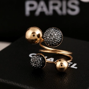 Detailed macro view of a gold spiral brass ring with black crystal pave spheres