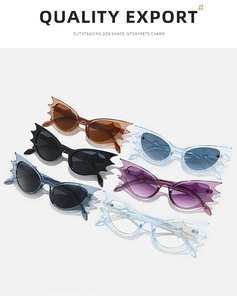Detail view of multi-color bat-shaped sunglasses in brown, black, blue, and purple tones