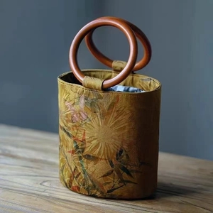 Detail of printed ethnic bucket bag with traditional floral patterns and wooden ring handles