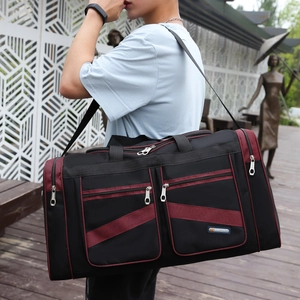 Large capacity black nylon travel duffel bag with red mesh detail and adjustable strap