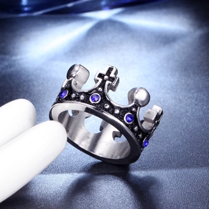 Close-up of vintage silver crown ring with blue gemstones on a jewelry display stand