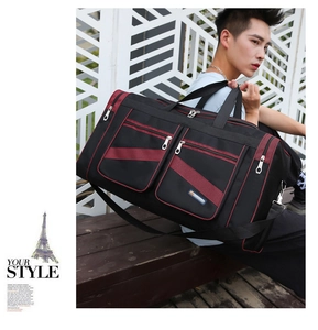 Man carrying a large black travel bag with red stripes during outdoor lifestyle use